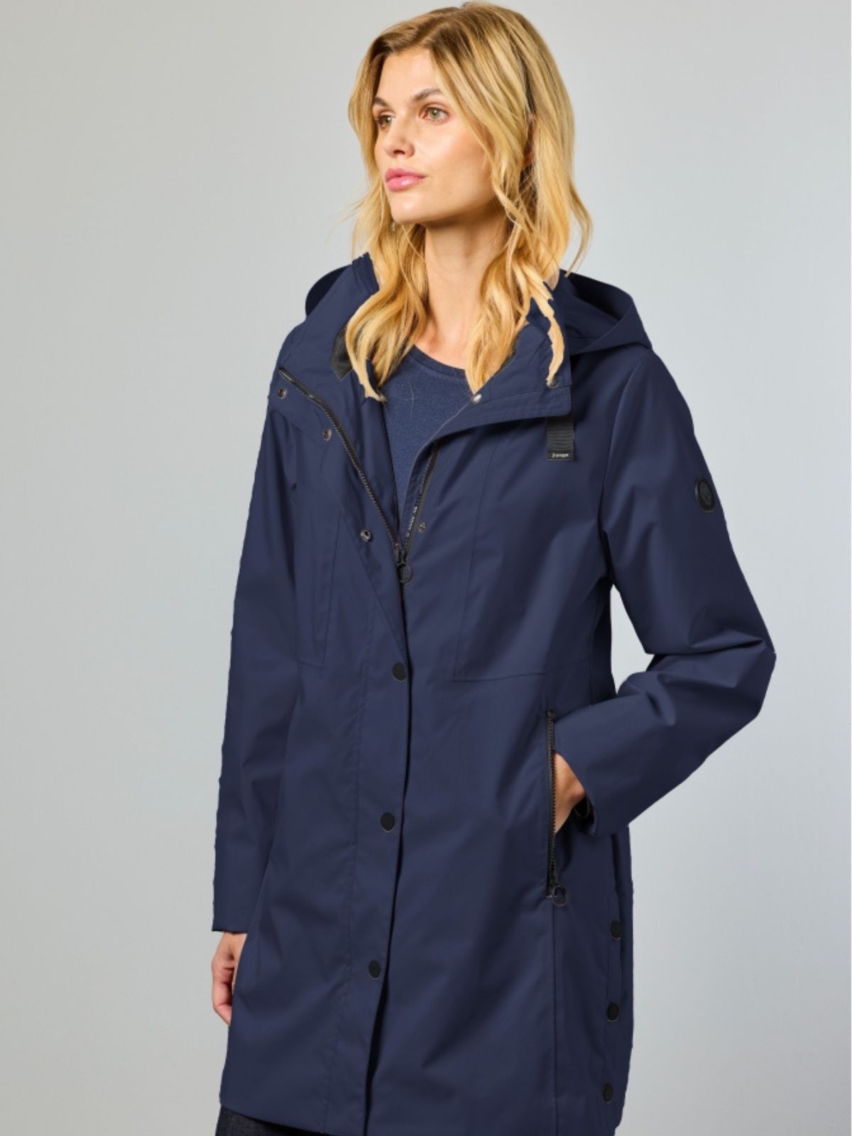 Noabelle är en lång vårjacka för dam i navy med en stilren silhuett och klassisk längd.