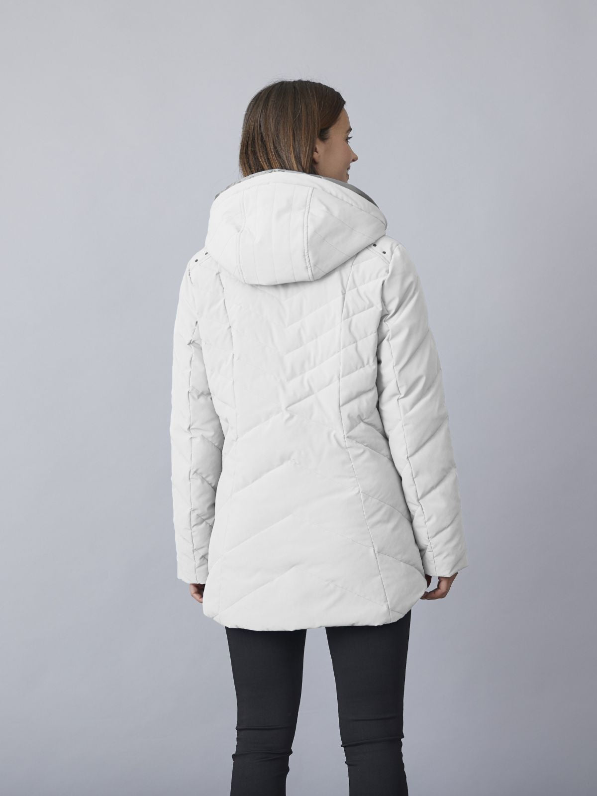 Modell iförd Kirsten kort övergångsjacka för kvinnor i winter white med huva, quiltad design och bekväm passform.