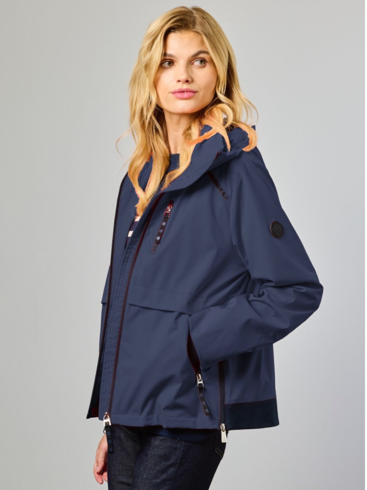 Nikki är en funktionsjacka för dam i navy med moderna detaljer och ett stilrent uttryck för våren.